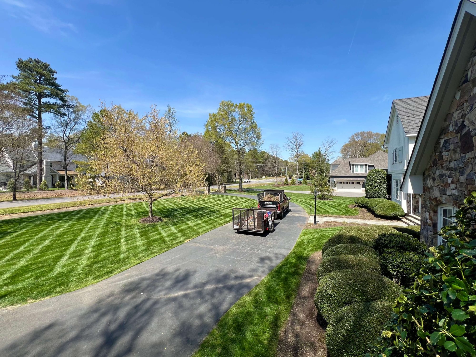 Our truck and trailer in driveway with freshly striped yard and trimmed bushes