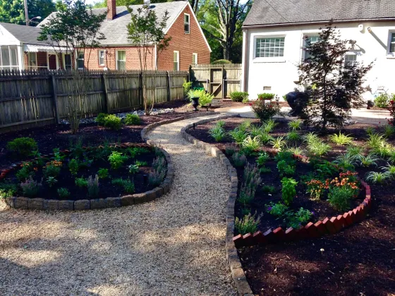 Stone walkway weaving through planted flower beds
