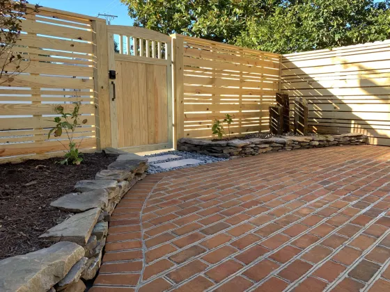 Back yard of the same property with new fence, gate, hardscaping and water feature